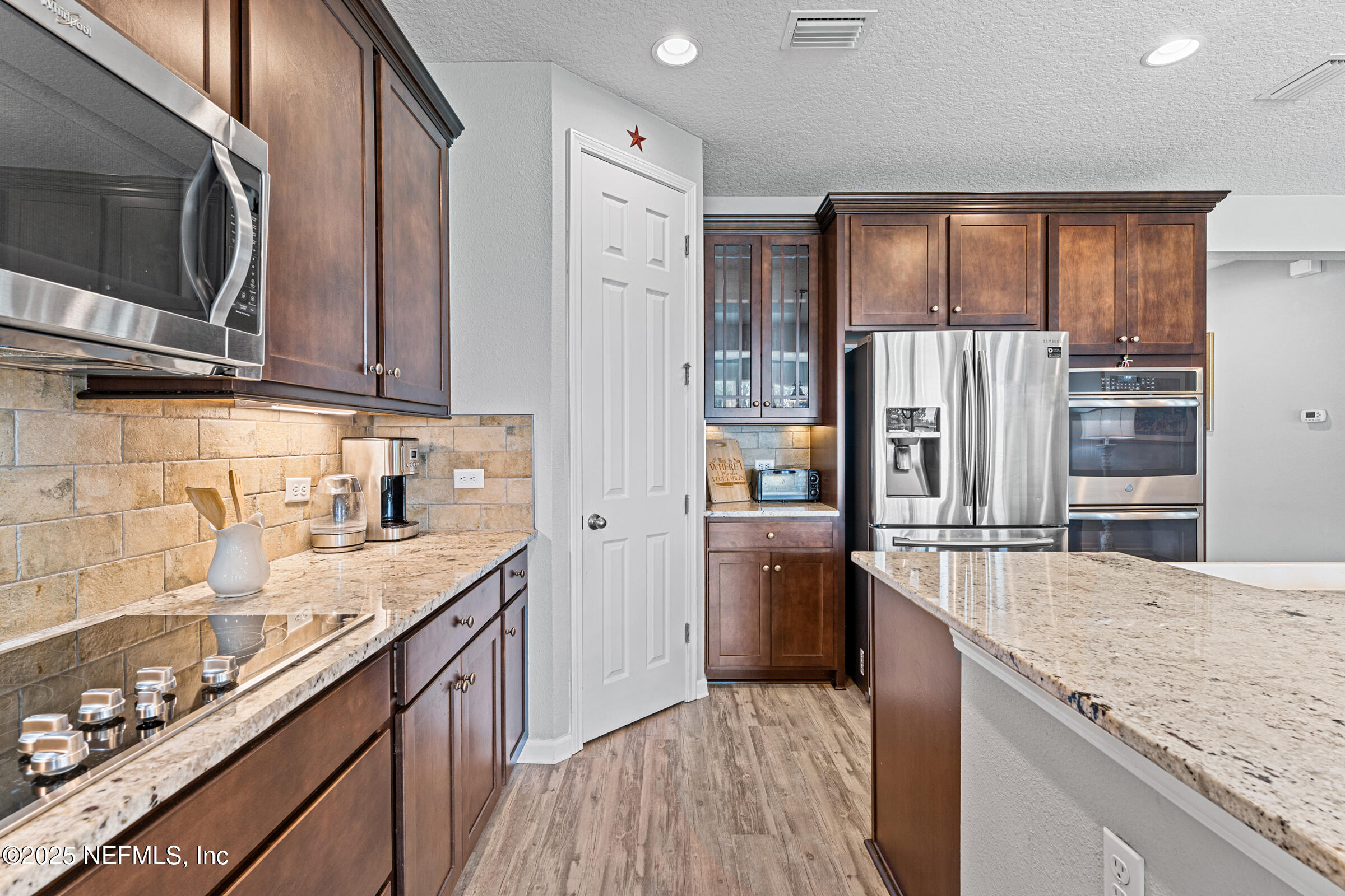 463 Tumbled Stone Way St. Augustine, FL 32086 - Photo 21 of 71 a kitchen with stainless steel appliances granite countertop a refrigerator and a stove top oven