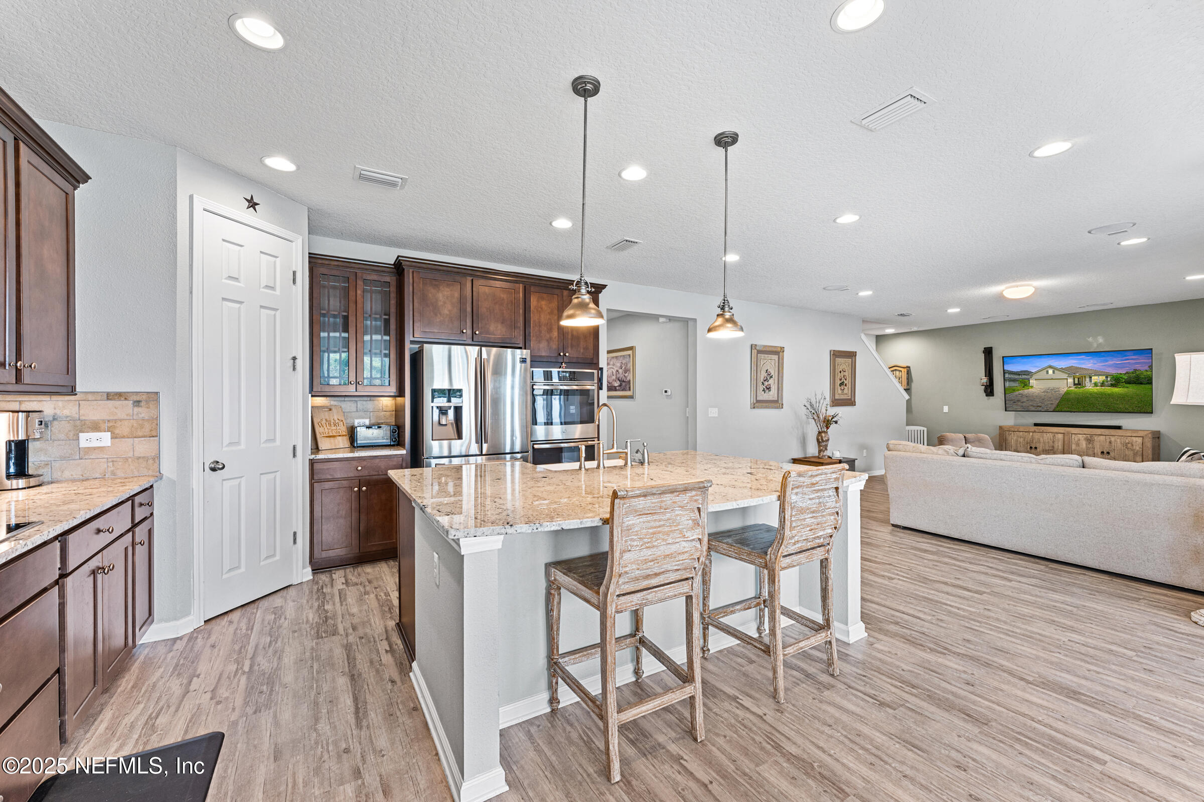 463 Tumbled Stone Way St. Augustine, FL 32086 - Photo 22 of 71 a dining room with stainless steel appliances kitchen island granite countertop a table chairs and a refrigerator