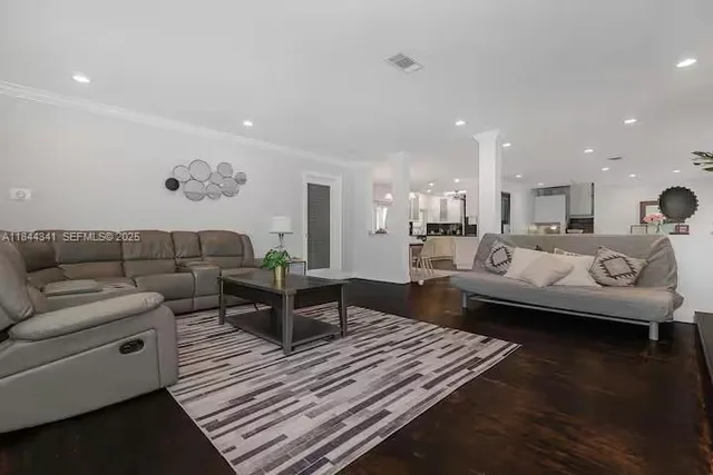 a living room with furniture and wooden floor