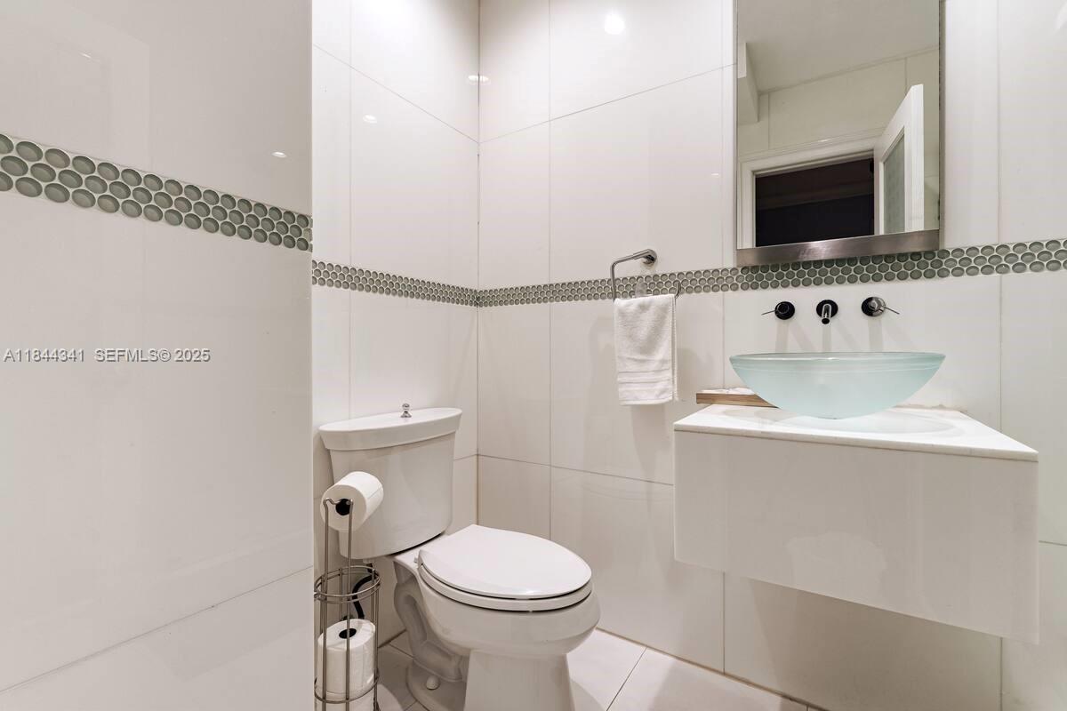 7475 Southwest 134th Street Pinecrest, FL 33156 - Photo 19 of 42 a bathroom with a sink a toilet and a mirror