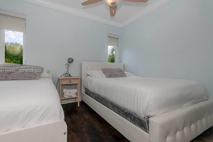 7475 Southwest 134th Street Pinecrest, FL 33156 - Photo 20 of 42 a bedroom with a bed and a chandelier