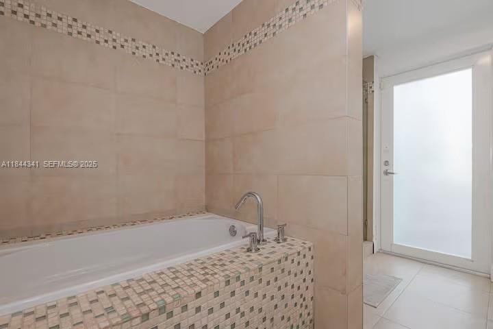 7475 Southwest 134th Street Pinecrest, FL 33156 - Photo 29 of 42 a bathroom with a granite countertop sink a mirror and bathtub