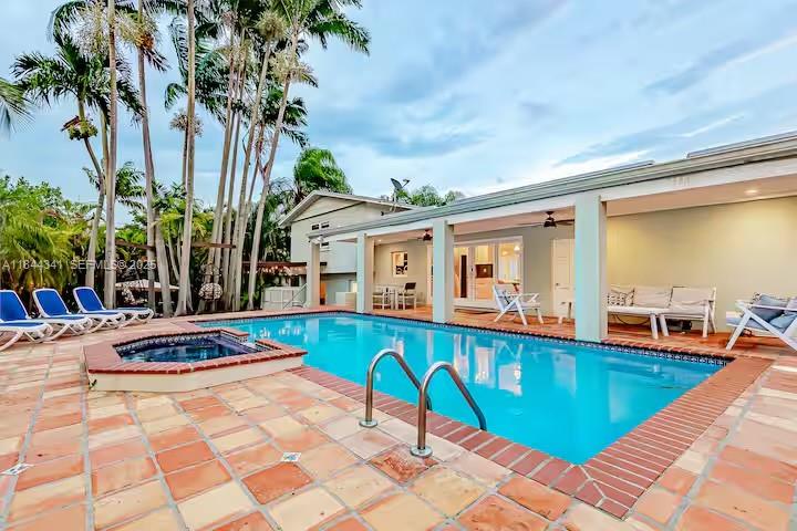 7475 Southwest 134th Street Pinecrest, FL 33156 - Photo 35 of 42 a swimming pool with outdoor seating and yard