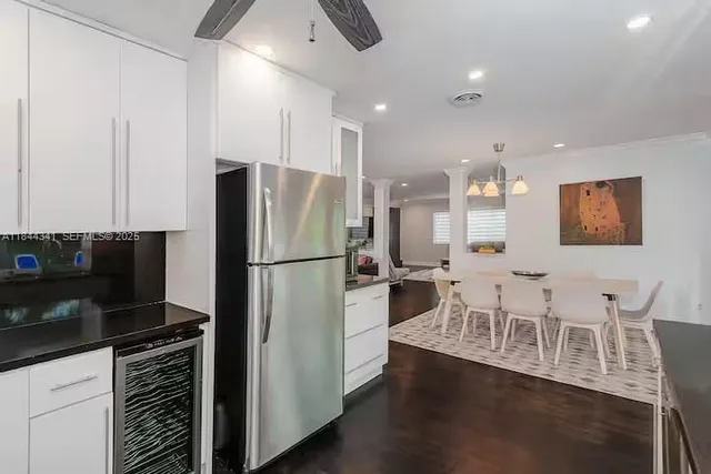 a kitchen with stainless steel appliances a refrigerator a stove a sink dishwasher with a dining table and chairs