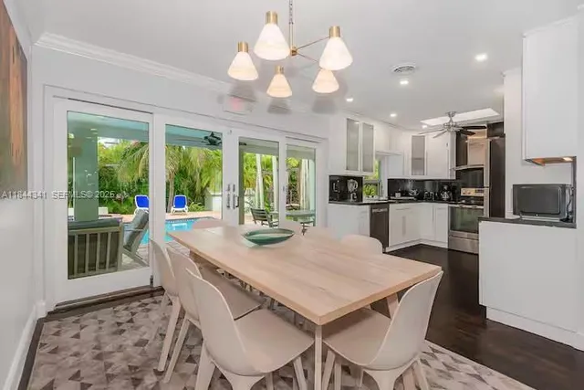 a view of a dining room with furniture a chandelier and wooden floor