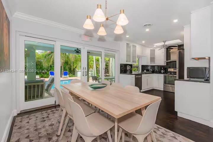 7475 Southwest 134th Street Pinecrest, FL 33156 - Photo 5 of 42 a view of a dining room with furniture a chandelier and wooden floor