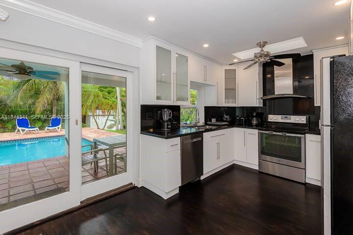 7475 Southwest 134th Street Pinecrest, FL 33156 - Photo 7 of 42 a kitchen with stainless steel appliances a stove top oven and a refrigerator