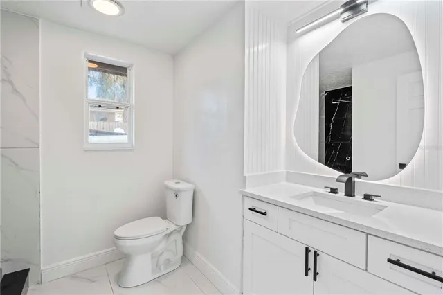 a bathroom with a toilet sink and mirror
