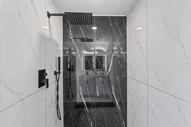 a view of an empty room with wooden floor and a ceiling fan