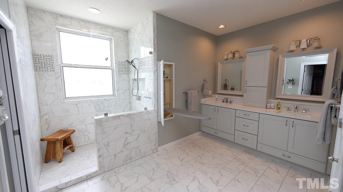 3820 Evander Way Raleigh, NC 27613 - Photo 19 of 30 The master bath was recently remodeled with a huge walk in shower, double vanity, large linen closet & water closet. There is a fold down ironing board for convenience as well.