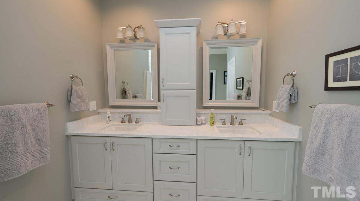 3820 Evander Way Raleigh, NC 27613 - Photo 20 of 30 The gorgeous vanity has lots of storage -drawers and cabinets. There is a quartz countertop & framed mirrors.