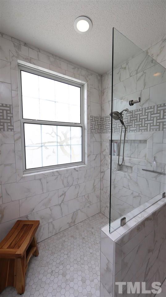 3820 Evander Way Raleigh, NC 27613 - Photo 21 of 30 There is a large walk in shower with frameless glass, niche for shower necessities.