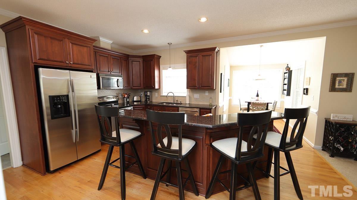 3820 Evander Way Raleigh, NC 27613 - Photo 10 of 30 The kitchen is beautiful with Alder (I believe) cabinetry, granite counters, tile backsplash, stainless appliances and under cabinet island. The breakfast bar has room for 4 stools so several people can be in the kitchen together.