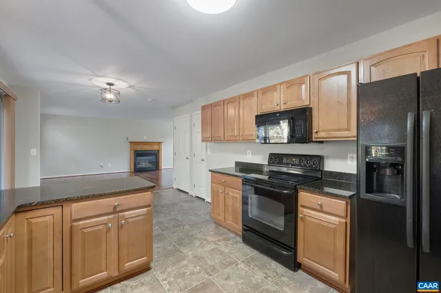a kitchen with granite countertop a refrigerator stove top oven and sink