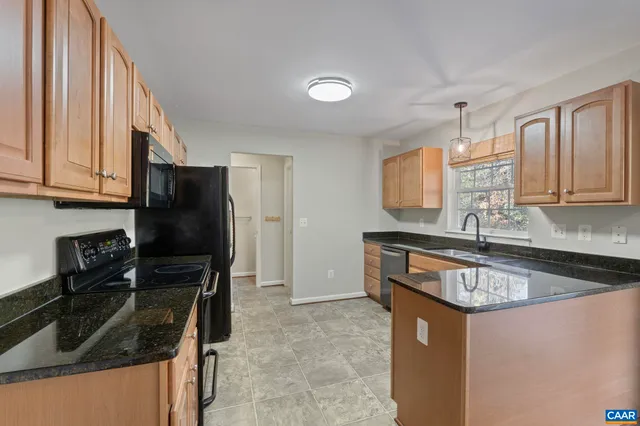 a kitchen with granite countertop a sink appliances and cabinets