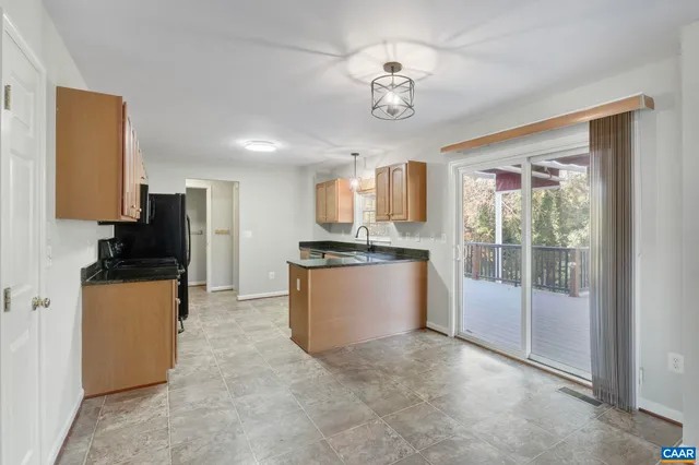 a view of kitchen with sink refrigerator and cabinets