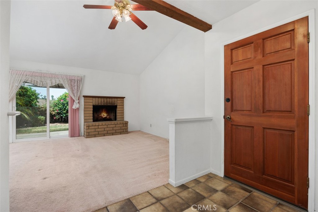 1744 Woodlark Lane Fallbrook, CA 92028 - Photo 4 of 38 an empty room with windows fireplace and flat screen tv