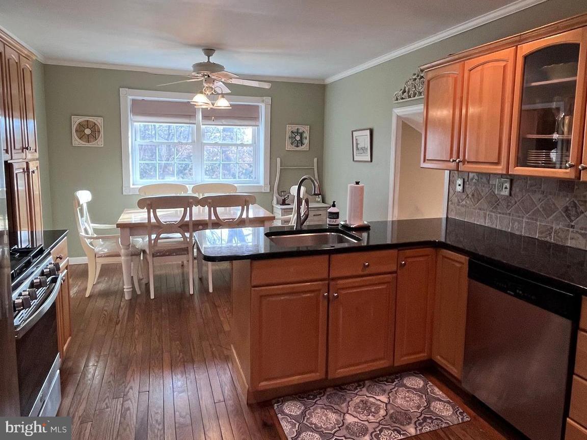145 Joanne Road Holland, PA 18966 - Photo 4 of 54 a kitchen with stainless steel appliances granite countertop a stove top oven a dining table and chairs with wooden floor