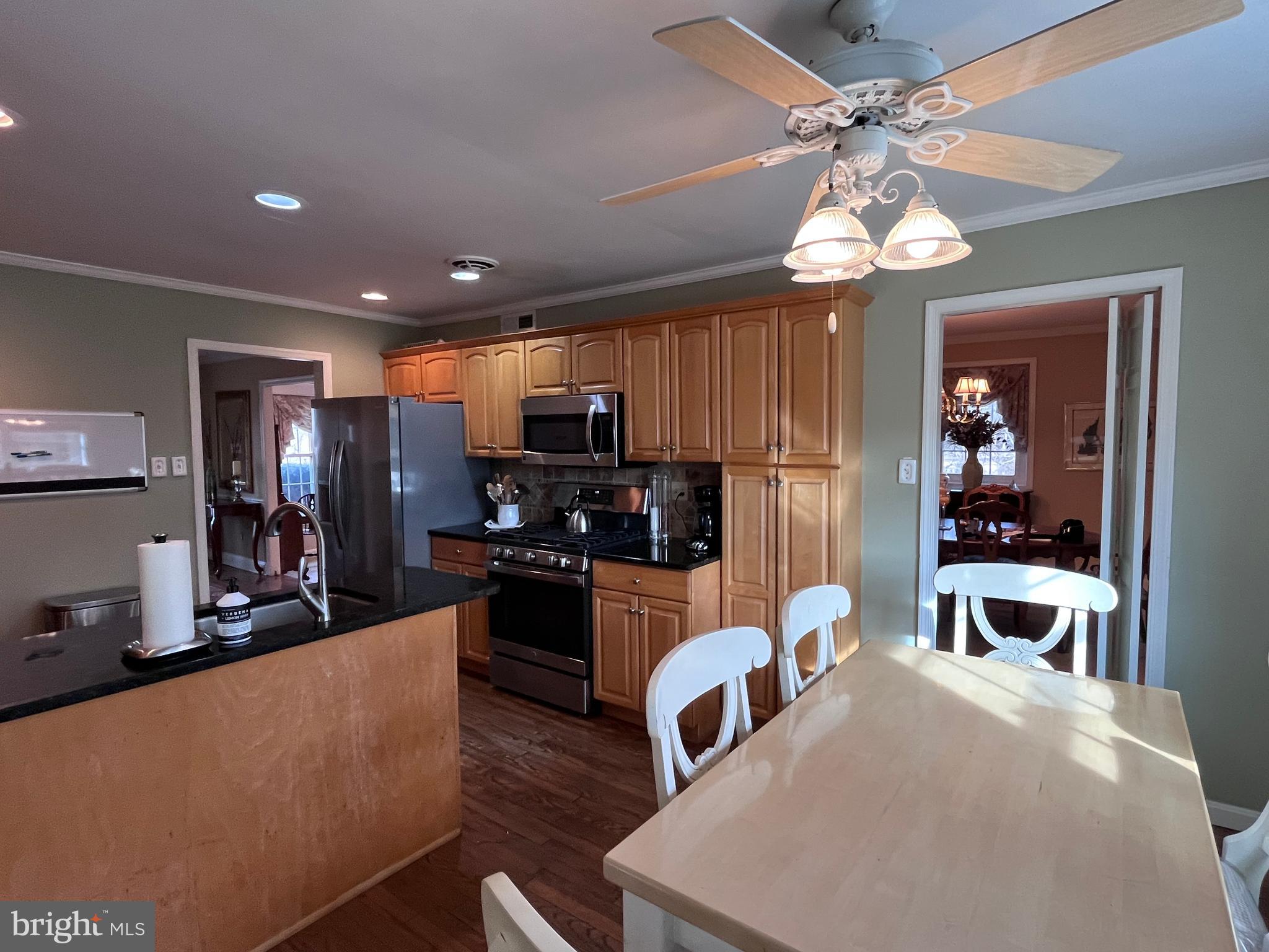 145 Joanne Road Holland, PA 18966 - Photo 8 of 54 a large kitchen with stainless steel appliances granite countertop a refrigerator a oven a sink a dining table and chairs with wooden floor