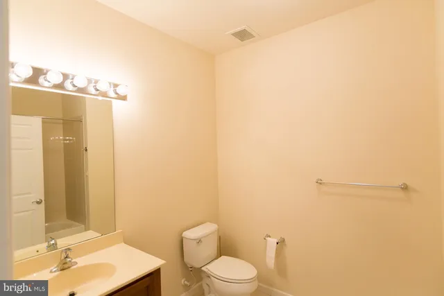 a bathroom with a toilet a sink and a mirror