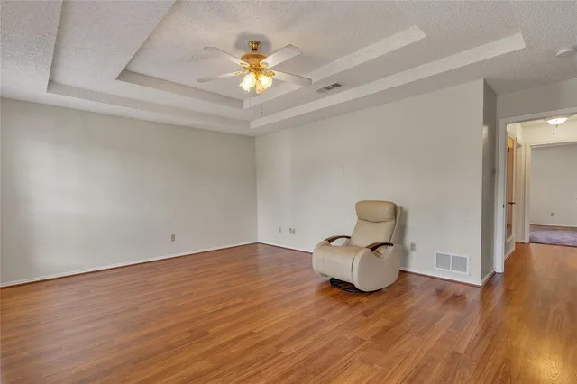 a view of a room with wooden floor and ceiling fan