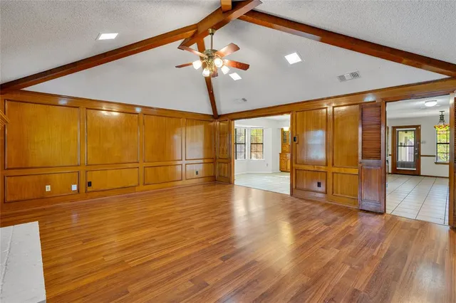a view of an empty room with wooden floor