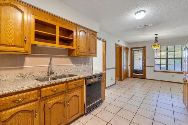 a kitchen with granite countertop a sink and cabinets