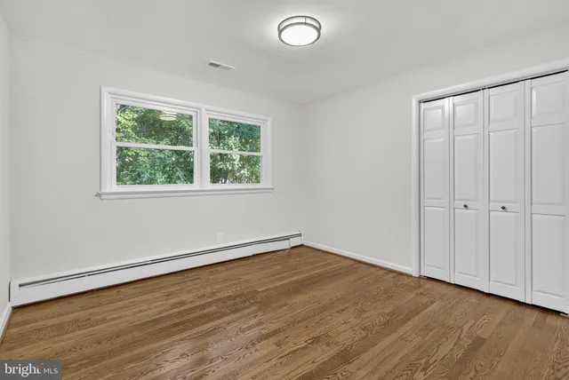 a view of an empty room with wooden floor