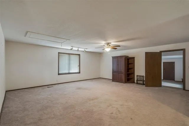 an empty room with furniture and a ceiling fan