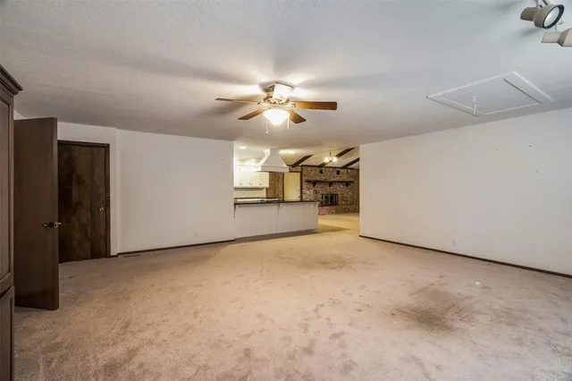 a view of a big room with chandelier fan and windows