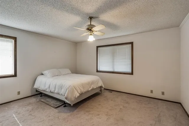 a bedroom with a bed and a ceiling fan