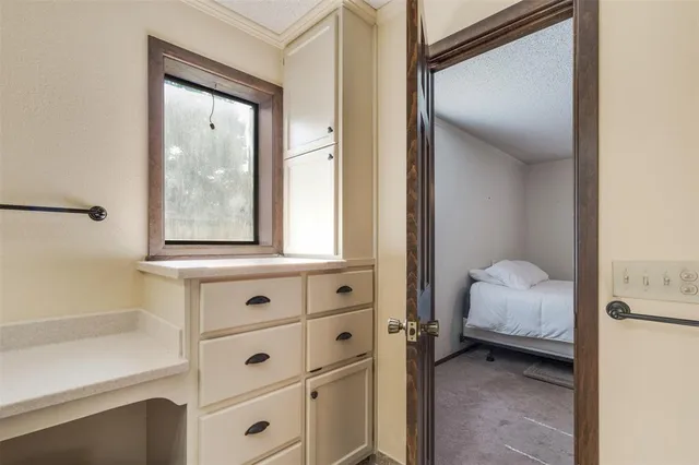 a view of bedroom with window and cabinet
