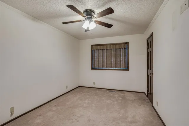 an empty room with windows and ceiling fan
