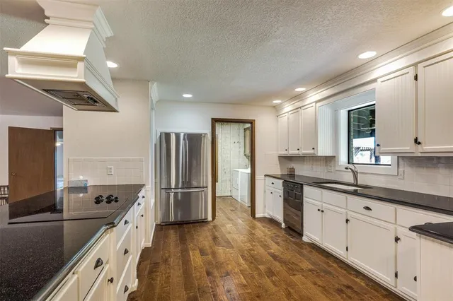 a kitchen with stainless steel appliances granite countertop a sink refrigerator and microwave
