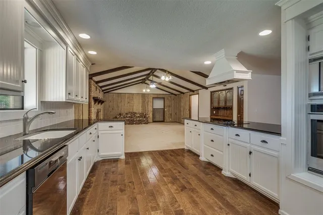 a kitchen with granite countertop a sink and a stove top oven