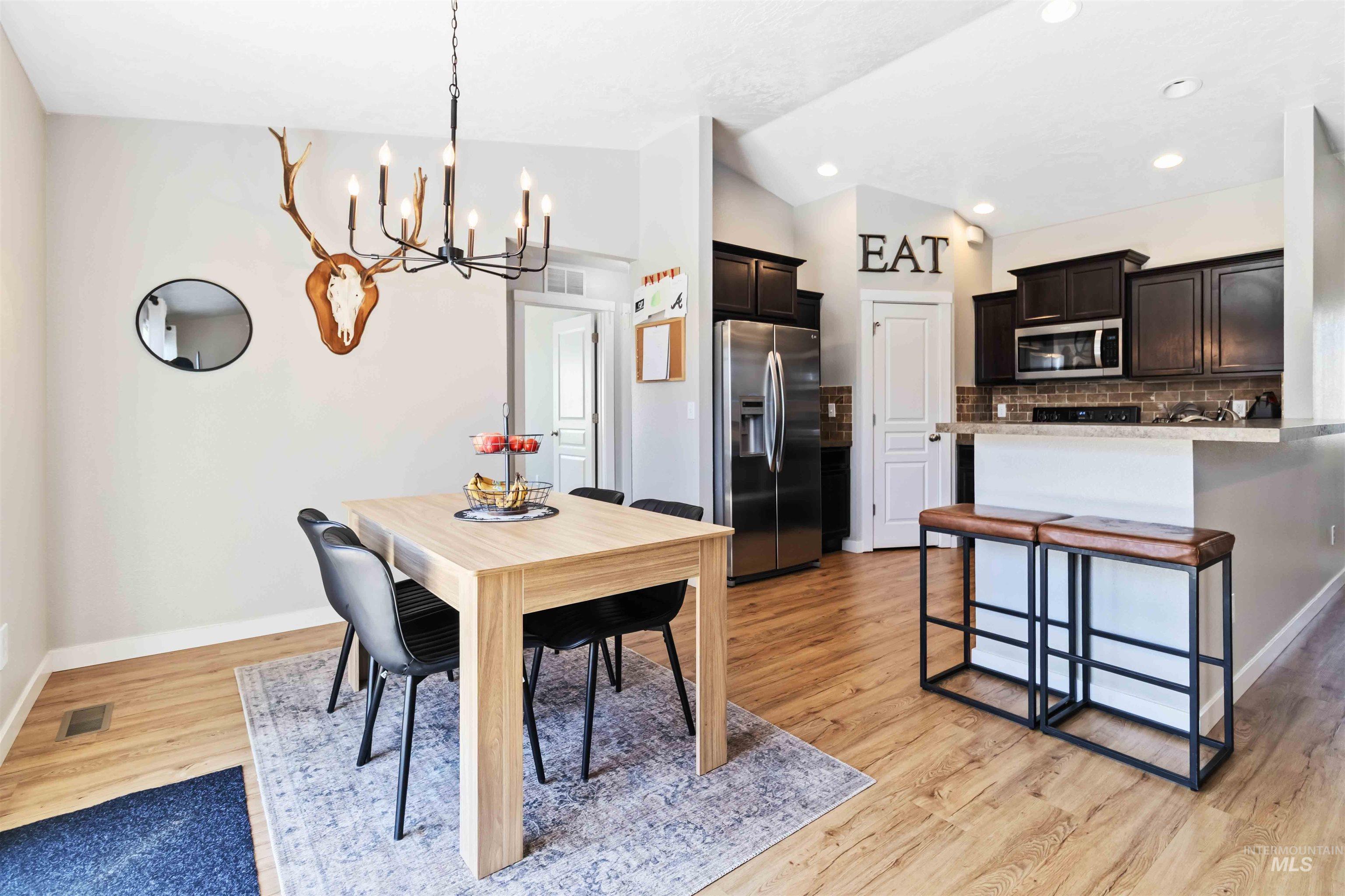 588 Gateway Avenue Middleton, ID 83644 - Photo 14 of 42 Dining space featuring vaulted ceiling, suspended lighting, and light wood-style floors