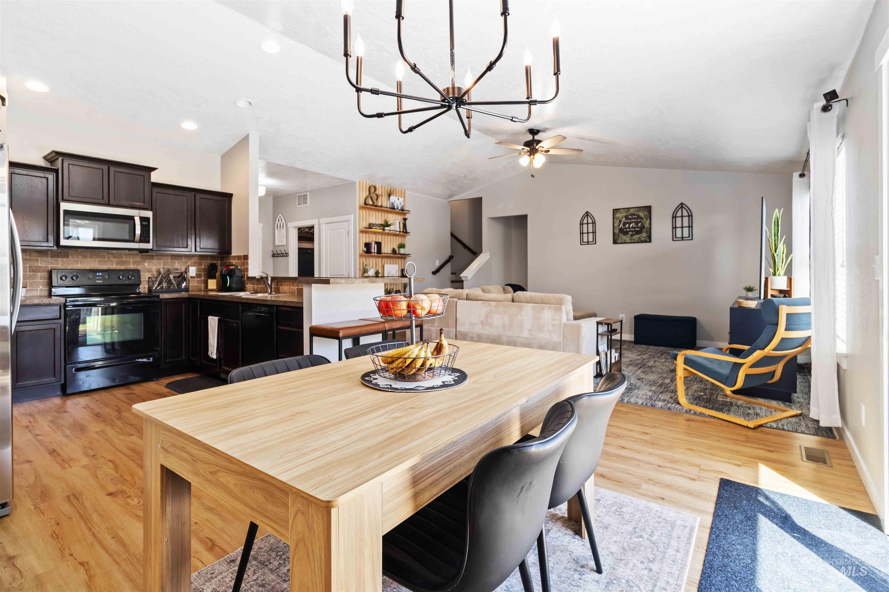 588 Gateway Avenue Middleton, ID 83644 - Photo 15 of 42 Dining space with a chandelier, light wood-type flooring, vaulted ceiling, and a ceiling fan