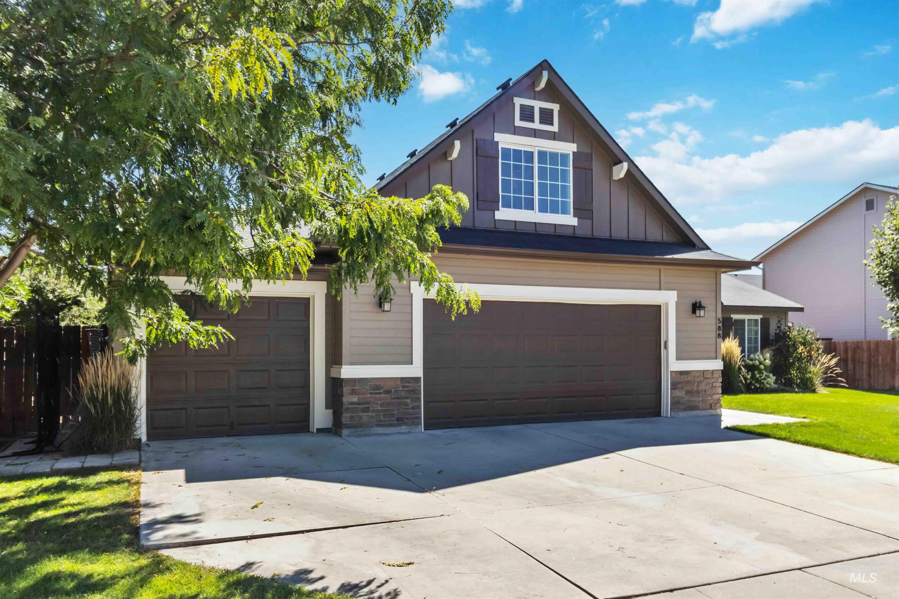 588 Gateway Avenue Middleton, ID 83644 - Photo 2 of 42 Craftsman-style house with board and batten siding, stone siding, driveway, and a garage