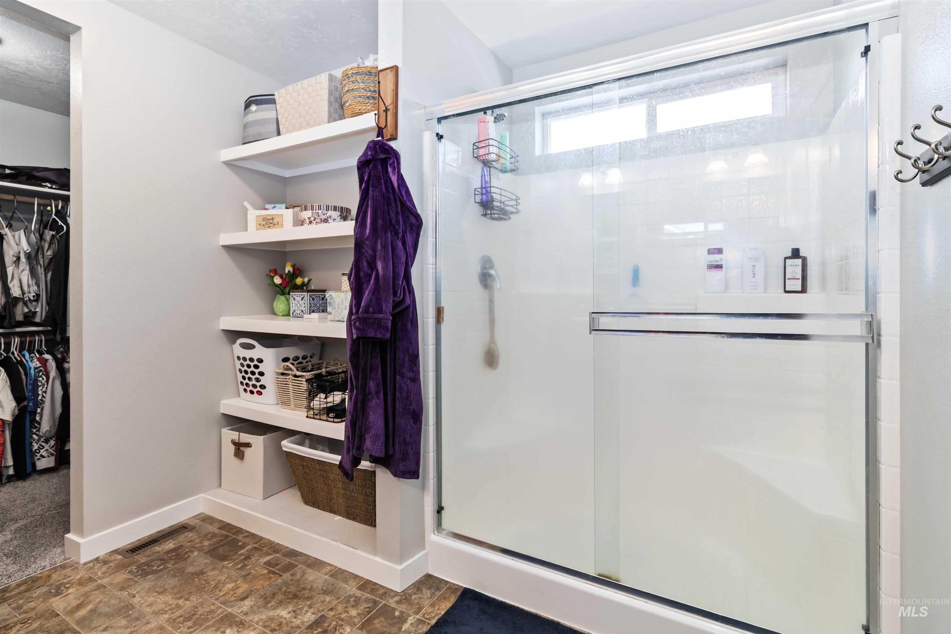 588 Gateway Avenue Middleton, ID 83644 - Photo 33 of 42 Full bath featuring a stall shower, stone finish flooring, and a walk in closet