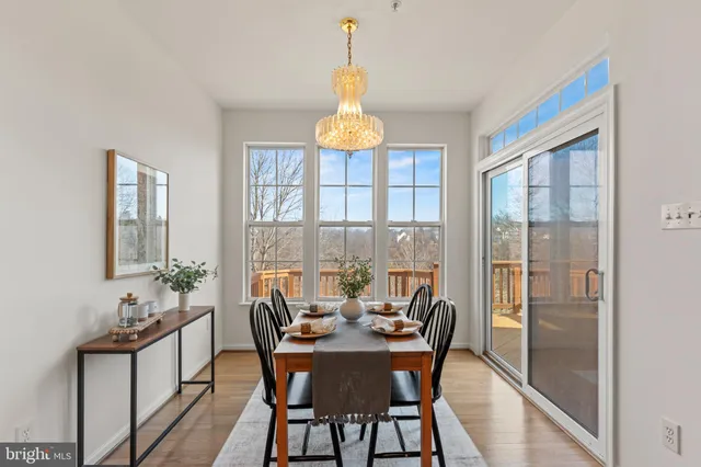 a dining room with furniture a chandelier and wooden floor