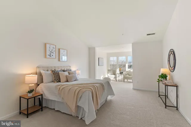 a bedroom with a bed large window and couch