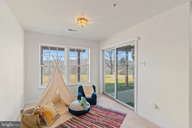 a living room with furniture and a floor to ceiling window