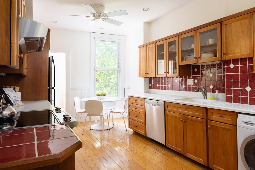 38 Garrison Road, Unit 2 Brookline, MA 02445 - Photo 7 of 18 a kitchen with stainless steel appliances granite countertop a stove a sink dishwasher and cabinets with wooden floor
