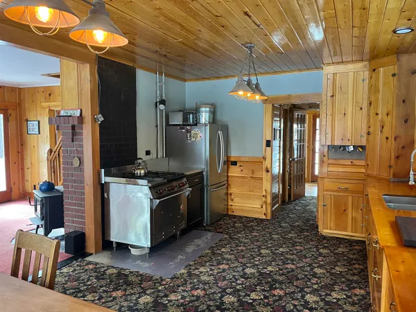 a kitchen with stainless steel appliances granite countertop a refrigerator a stove and a sink