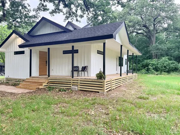 a view of house with backyard and trees