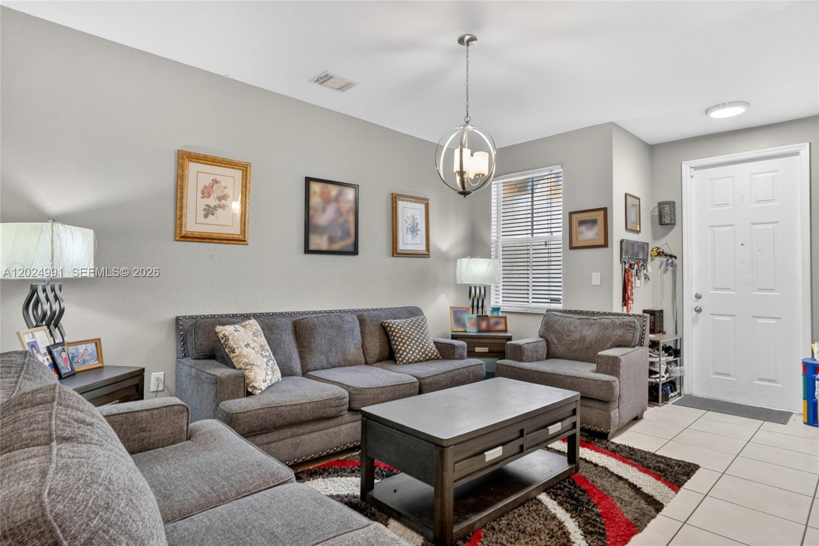 16651 Southwest 79th Terrace Miami, FL 33193 - Photo 8 of 34 a living room with furniture a couch and a chandelier