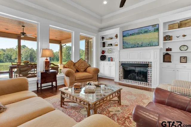a living room with furniture a floor to ceiling window and a fireplace
