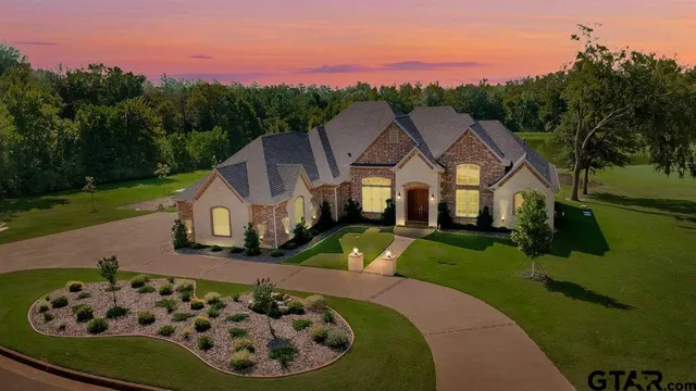 a view of a white house with a big yard and large trees