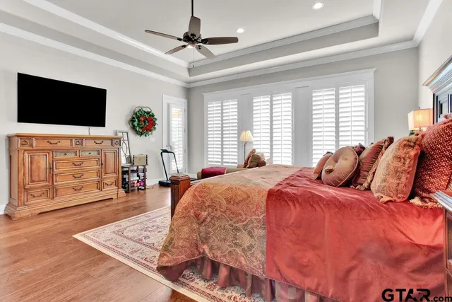 a spacious bedroom with a bed a flat screen tv and a couch