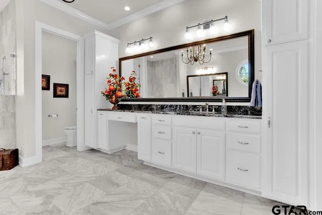 a view of cabinets a sink and a mirror in a room